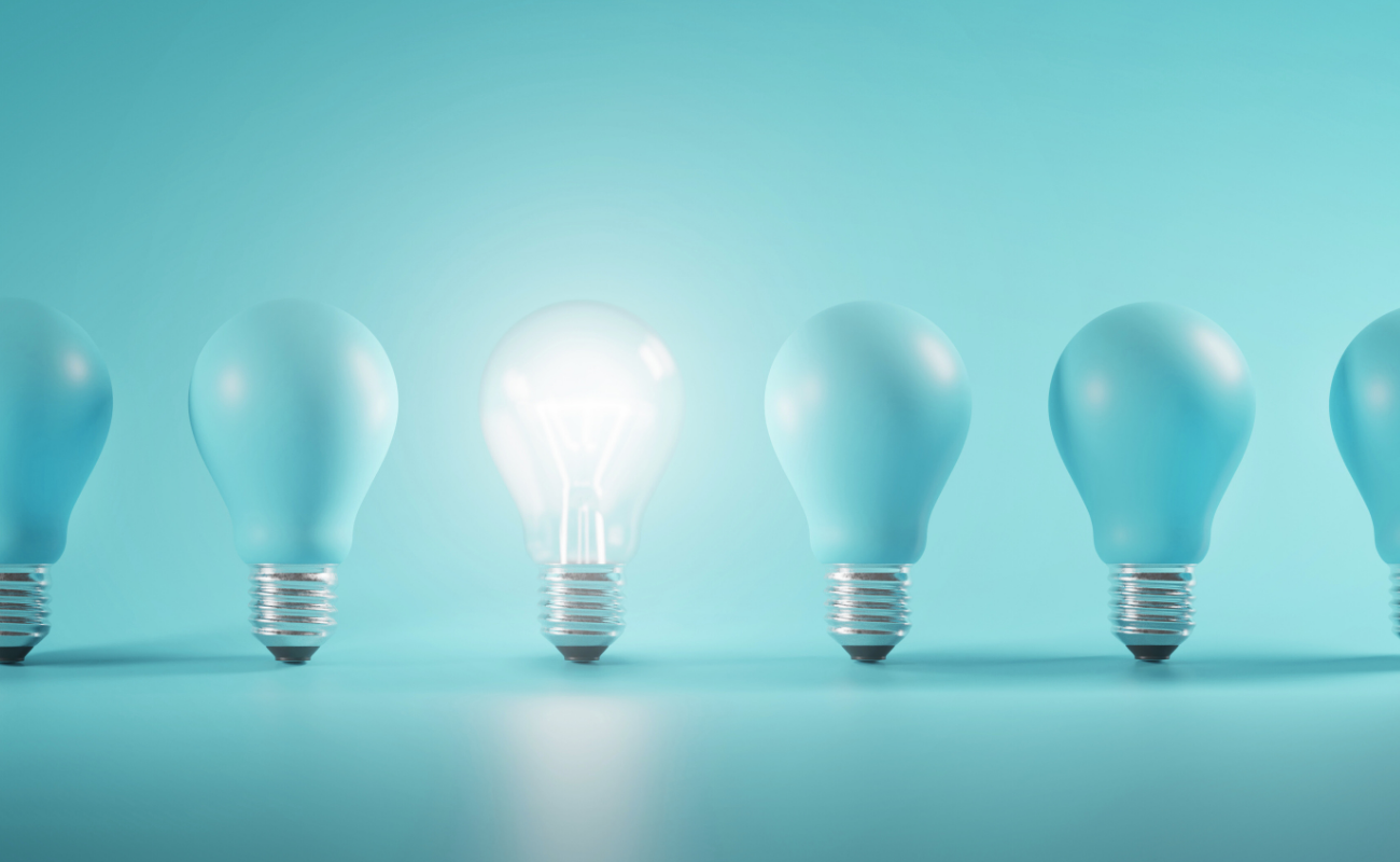 Lightbulbs on Teal Background – Magtyne Ideas and Innovation Visual Row of glowing lightbulbs on teal background