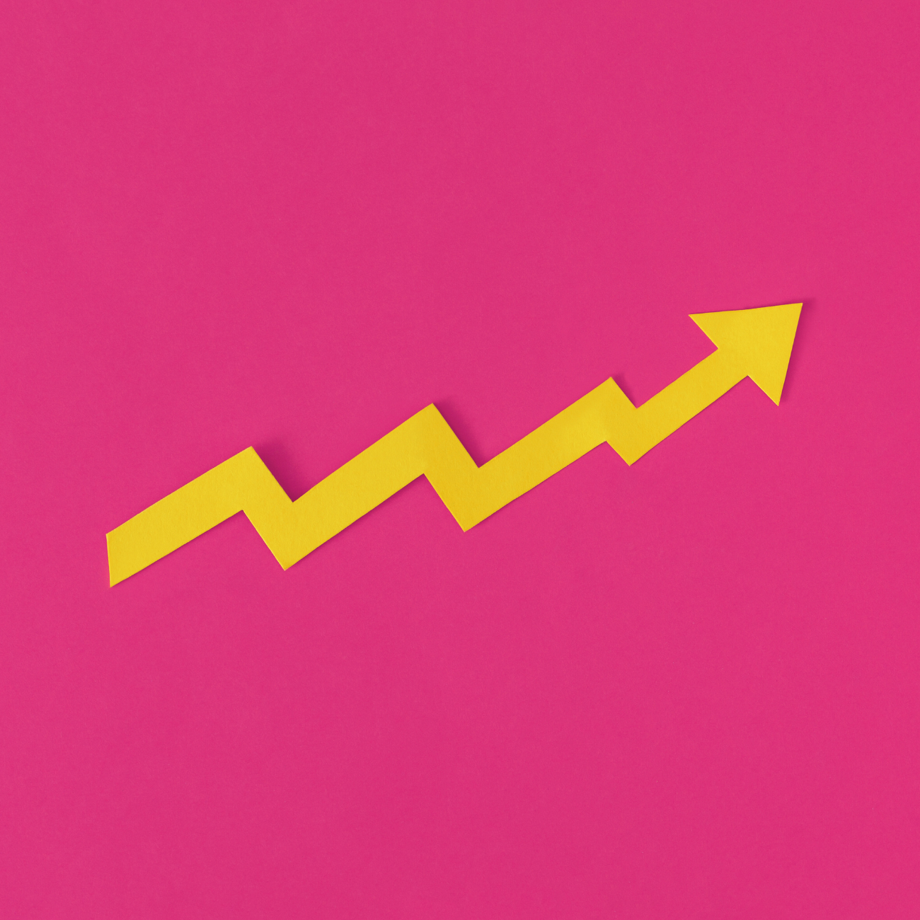 magtyne image_yellow arrow graph increrasing_pink bg Open book pages fanned out against pink background