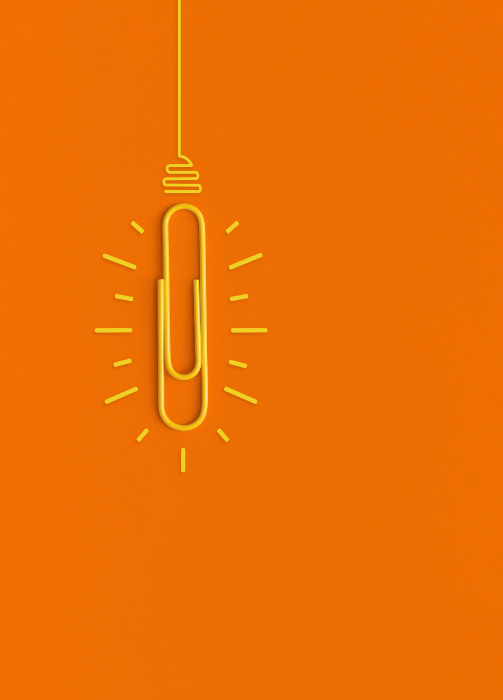 magtyne image_yellow paperclip-lightbulb_orange bg Person wearing orange jacket holding smartphone against bright background
